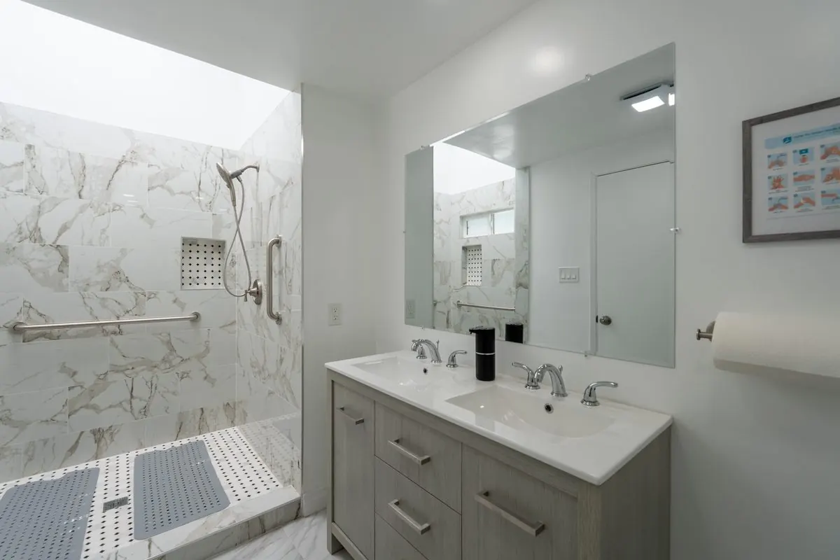 Modern bathroom with a walk-in marble shower and safety grab bars