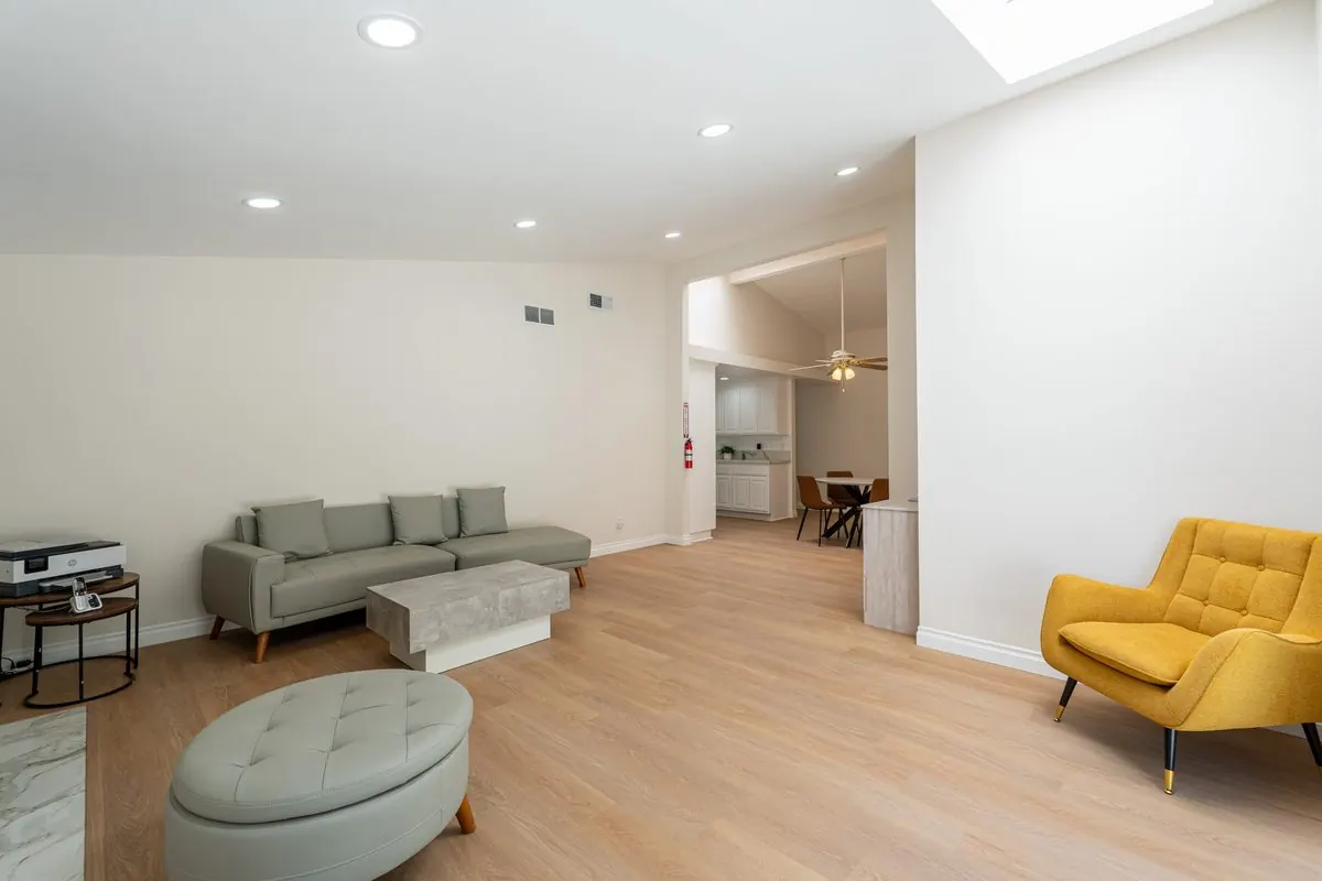 Family lounge with a sage green sofa and mustard yellow armchair