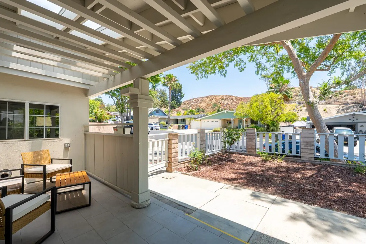 Covered front porch with comfortable seating and a garden view